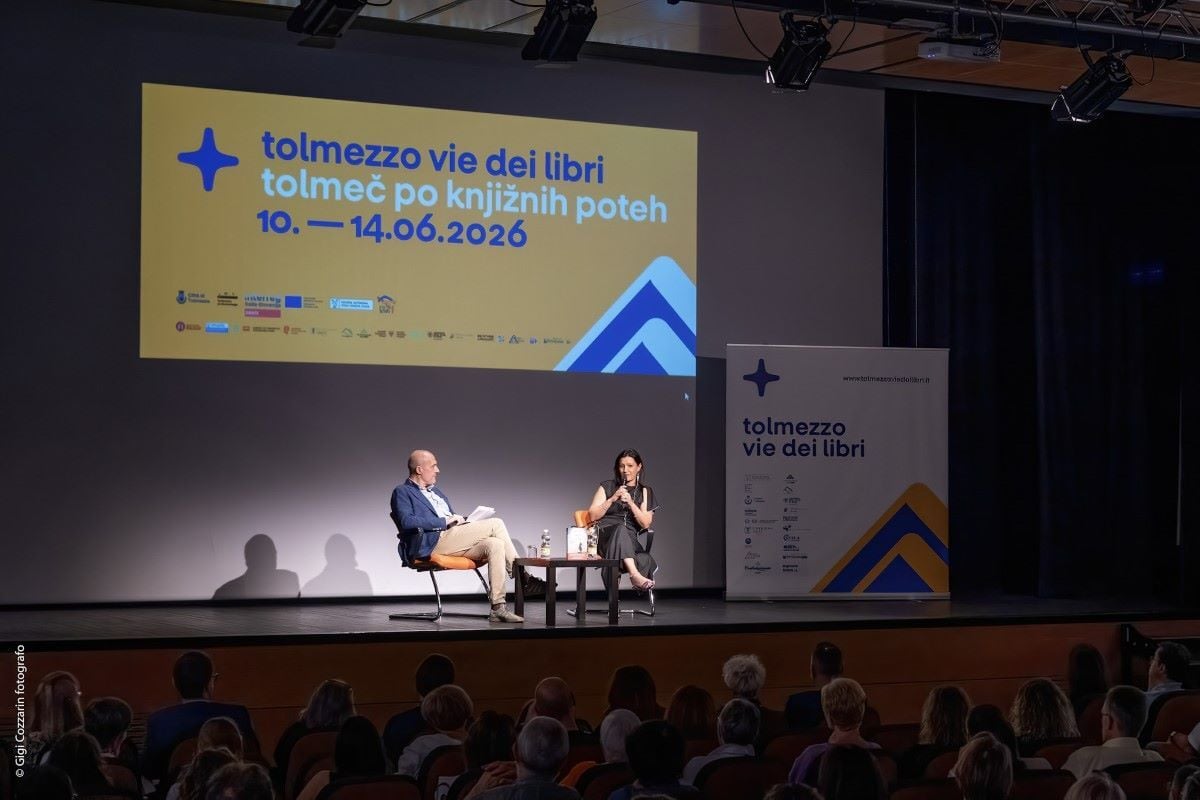 Ilaria Tuti parla al microfono durante un evento con Alberto Garlini